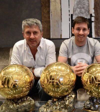 Jorge Messi and Lionel Messi posing in front of Messi's achievements